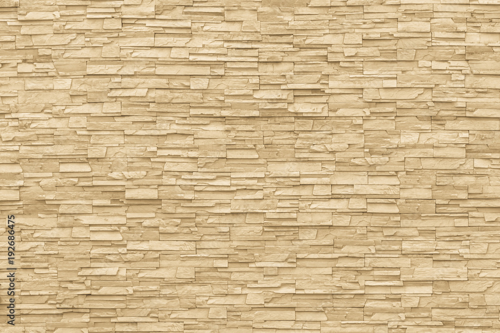 Rock stone brick tile wall aged texture detailed pattern background in yellow cream beige color