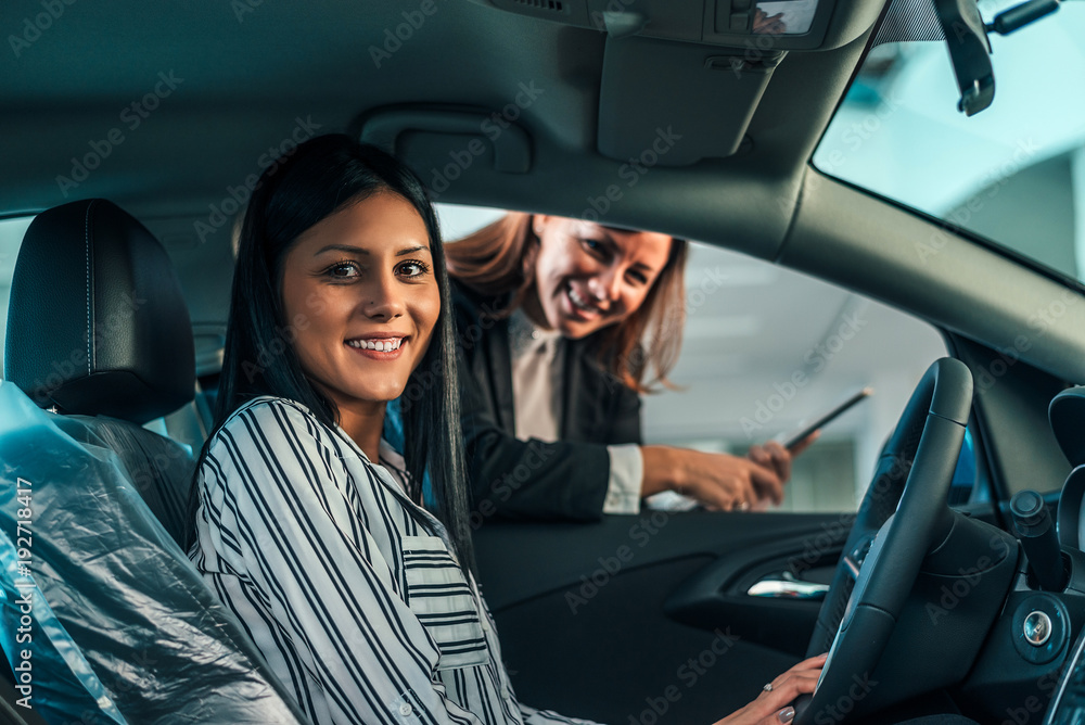 Young woman sitting in brand new car.