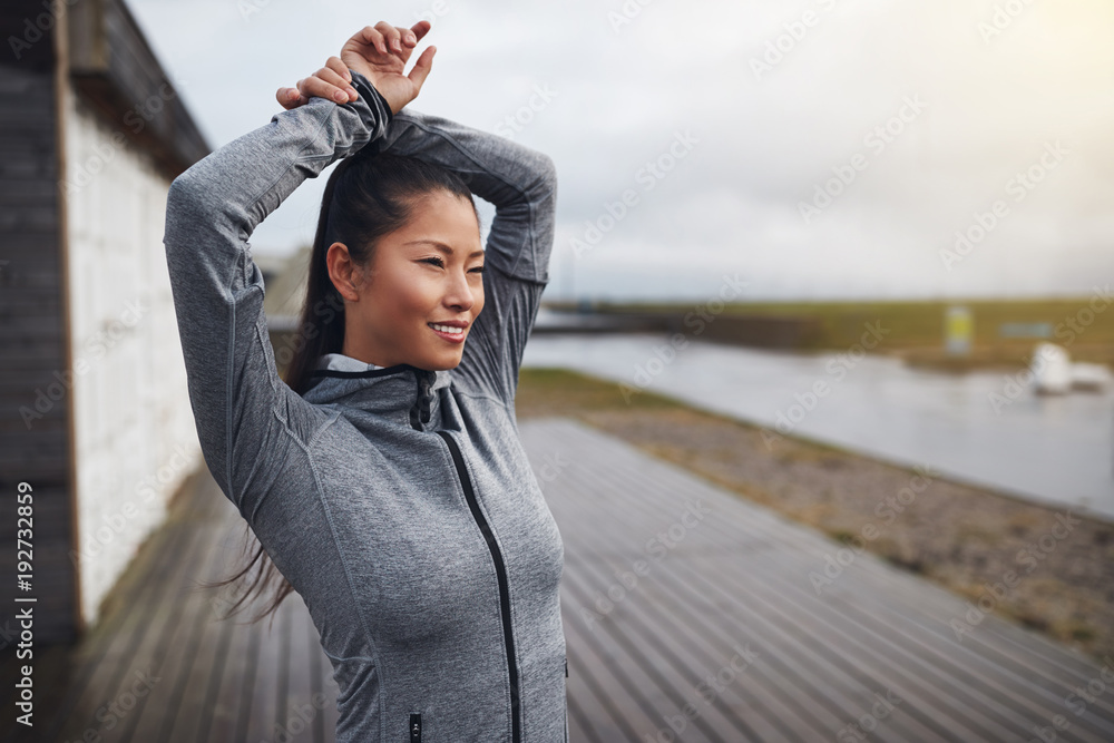 微笑的年轻亚洲女性跑步前热身