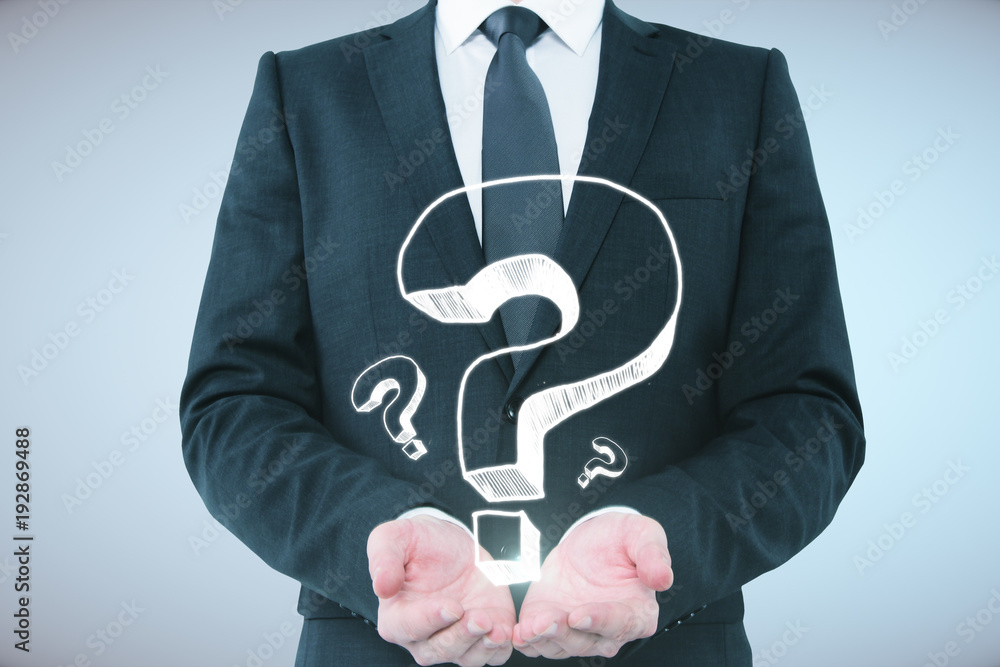 Businessman holding question marks