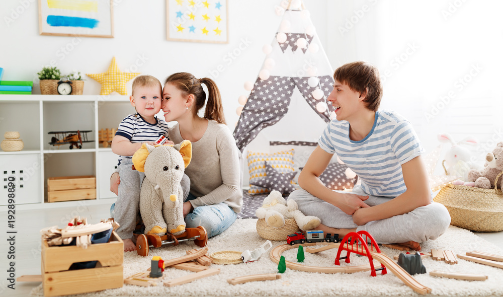 family mother father and   son playing together in childrens playroom