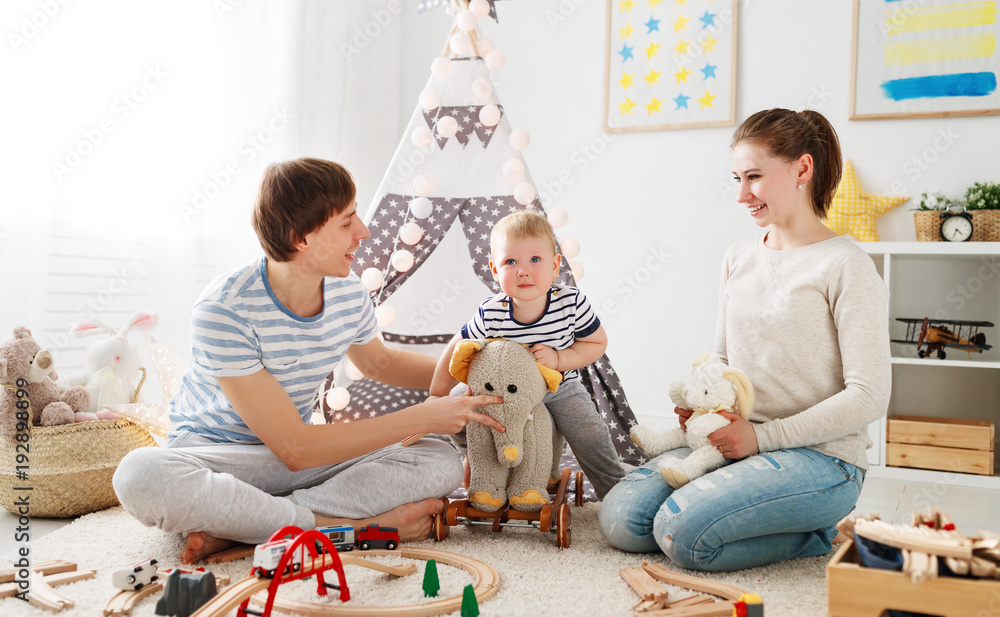 family mother father and   son playing together in childrens playroom