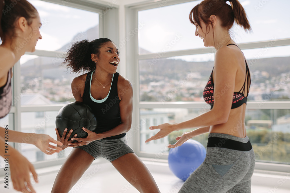 Women enjoying exercising with medicine ball at gym