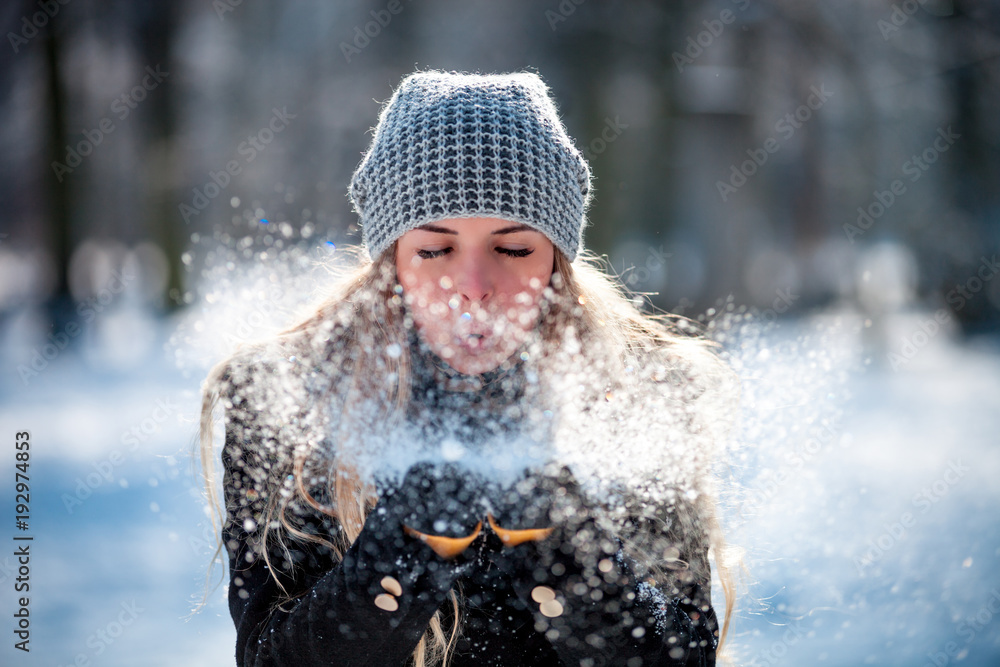 冬天的女人在户外吹雪，雪花纷飞