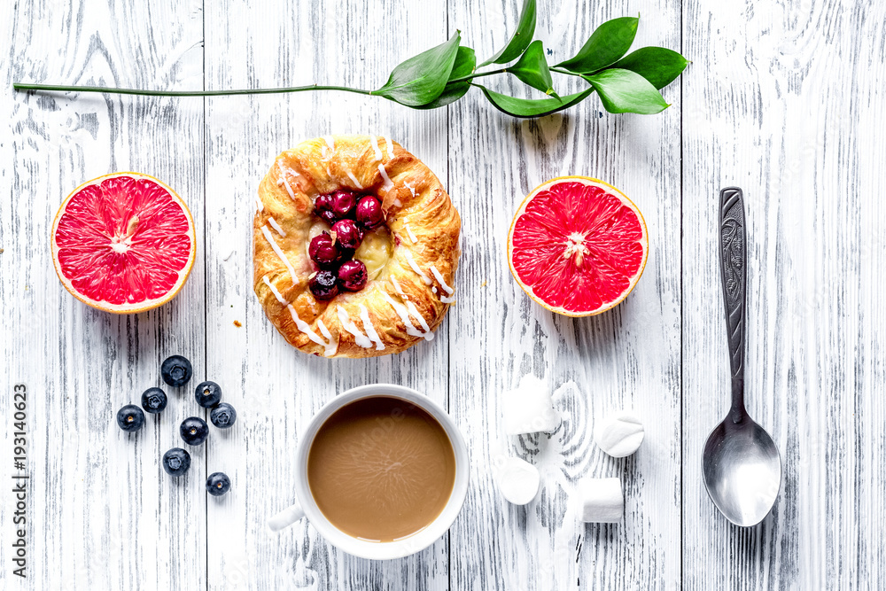 Breakfast concept with flowers on wooden background top view