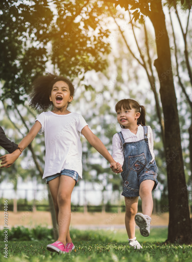 孩子们的友谊——女孩和朋友牵着手散步和玩耍