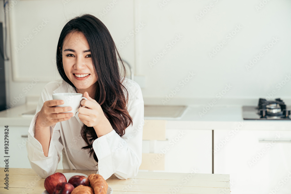 早上刚醒来的亚洲女孩很放松。她打开窗户接受阳光