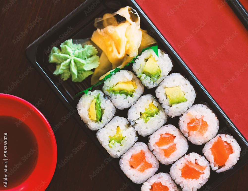 Sushi Takeaway Box mit Lachs und Avocado Rolls, dazu Ingwer , Wasabi und Sojasoße