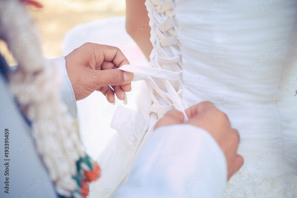 wedding dresses laces, Closeup toned photo of beautiful bride tying up her wedding dress