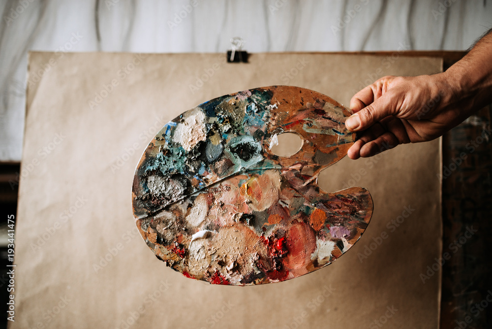 Image of a painters hand with palette.