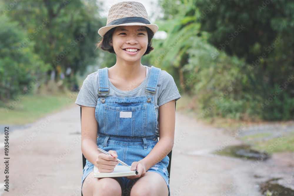 亚洲女人拿着书微笑的画像