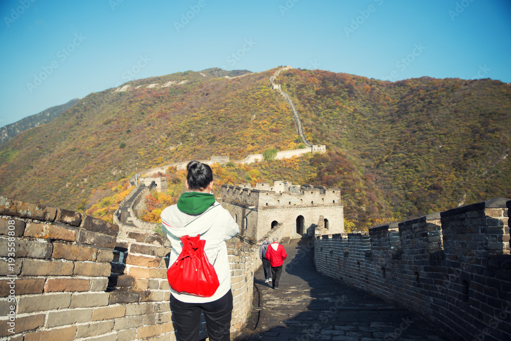 年轻女孩游客在著名的八达岭旅游景点从背后眺望中国长城