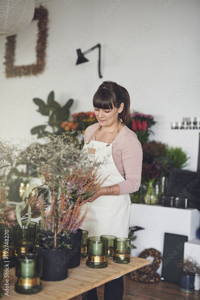 微笑的女花店老板在她的店里插花