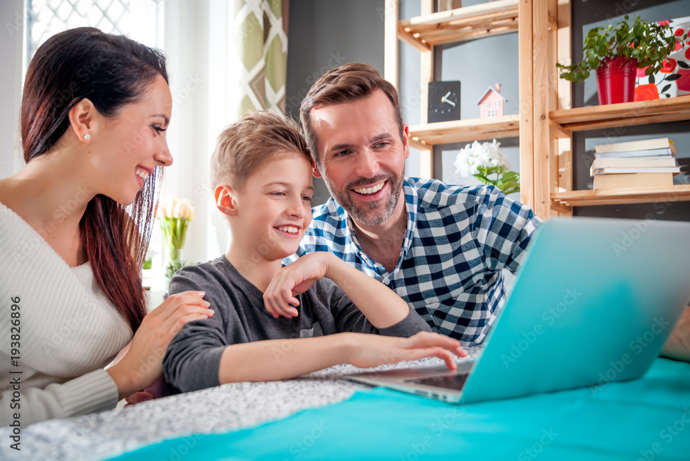 Happy family using laptop together at home