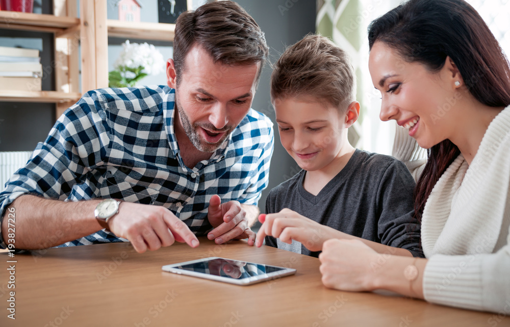 Happy family using tablet together at home