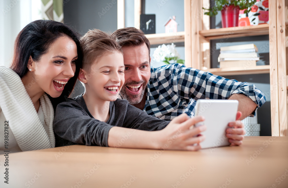 Happy family using tablet together at home