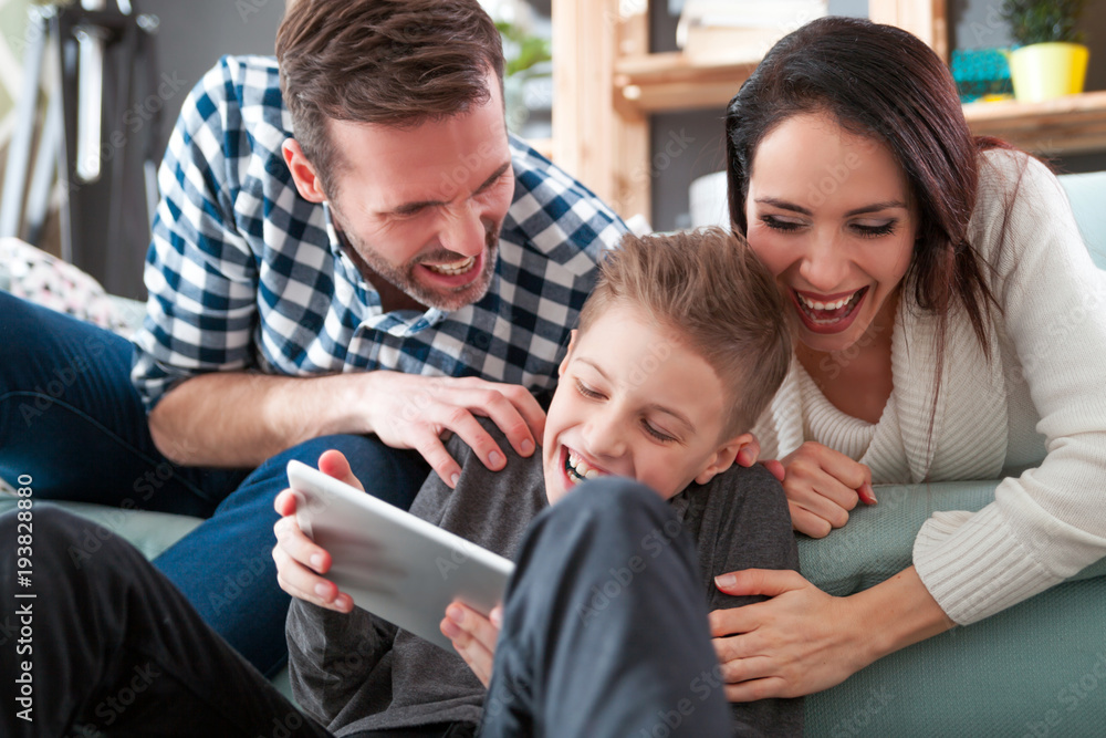 Happy family on sofa using tablet together at home