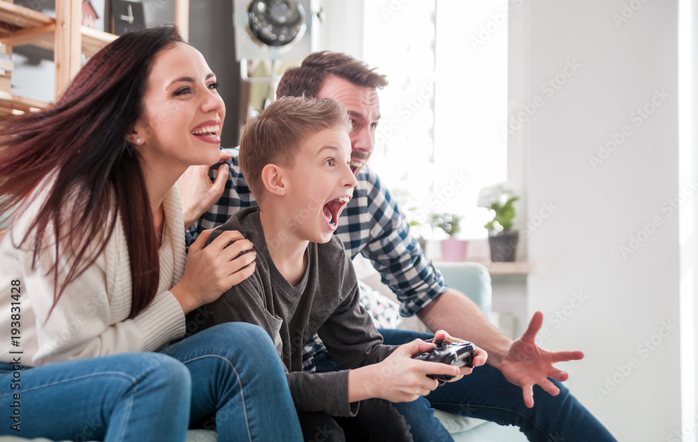 Excited family playing video game on the console at home