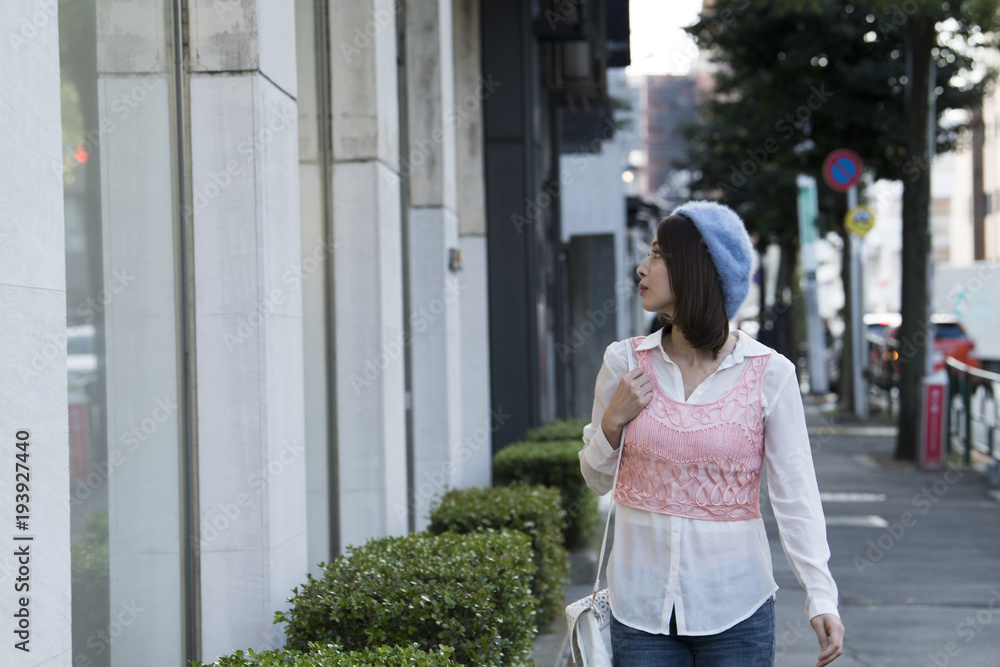 女性は休日に都会を散歩する。