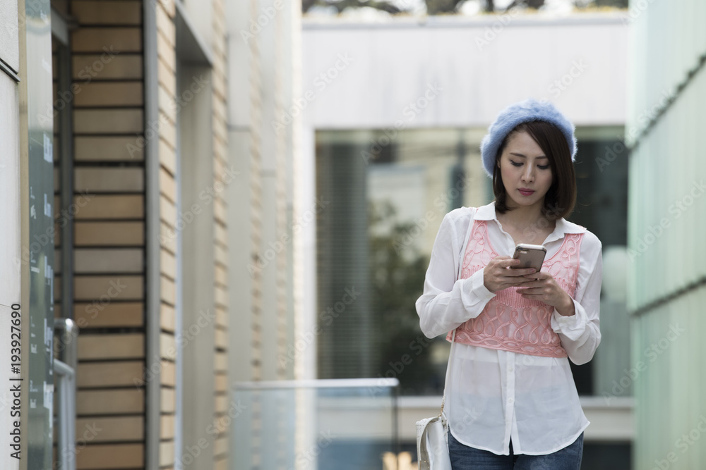 スマートフォンで道を探している女子大学生。