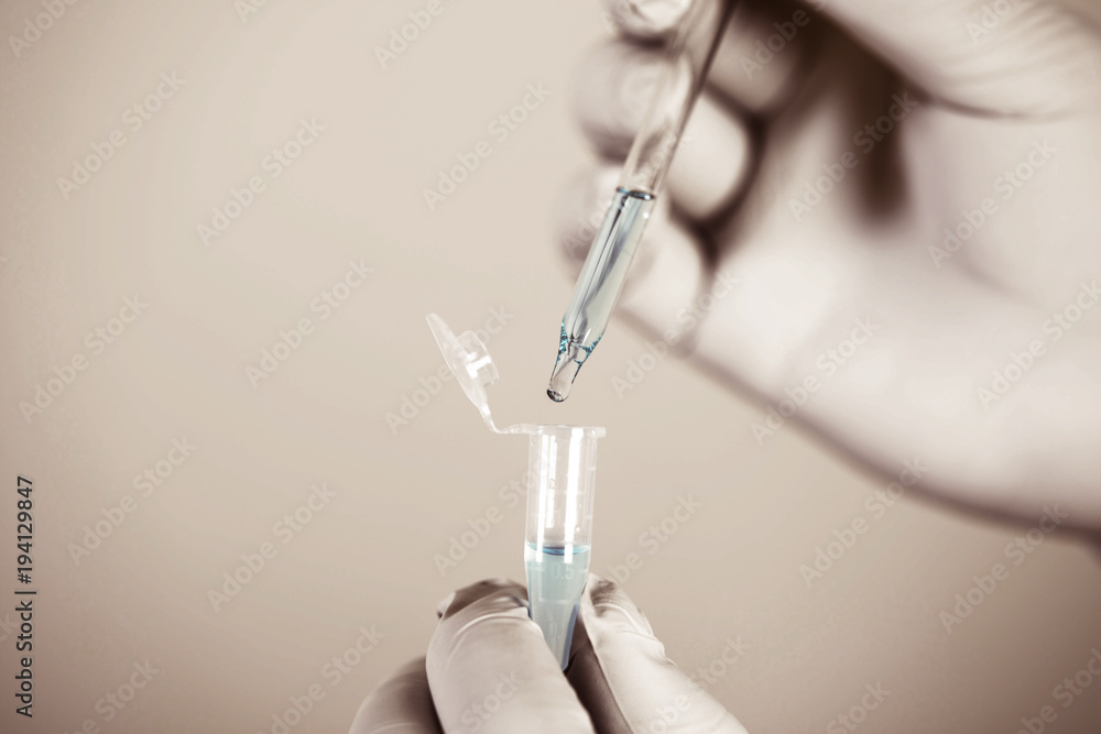 Close up a scientist working in laboratory to analyze blue extracted of DNA  molecules in micro tube