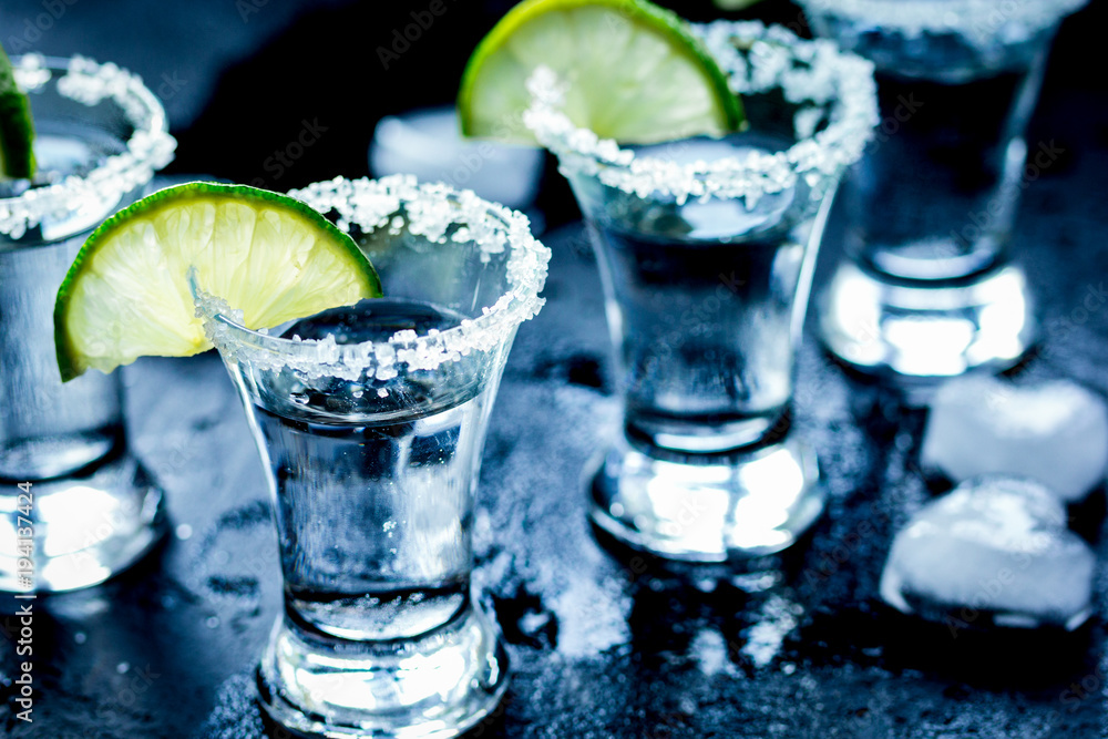 Alcohol shots with lime and salt on black background