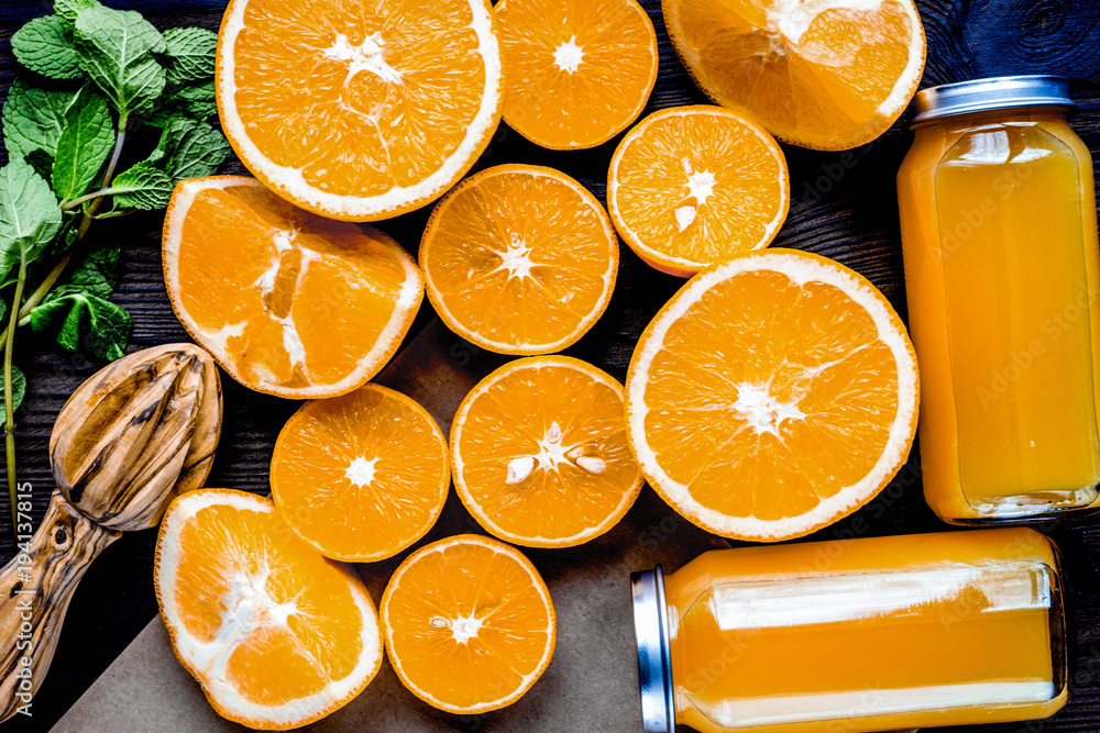 Orange juice in bottle with slices and mint on table top view