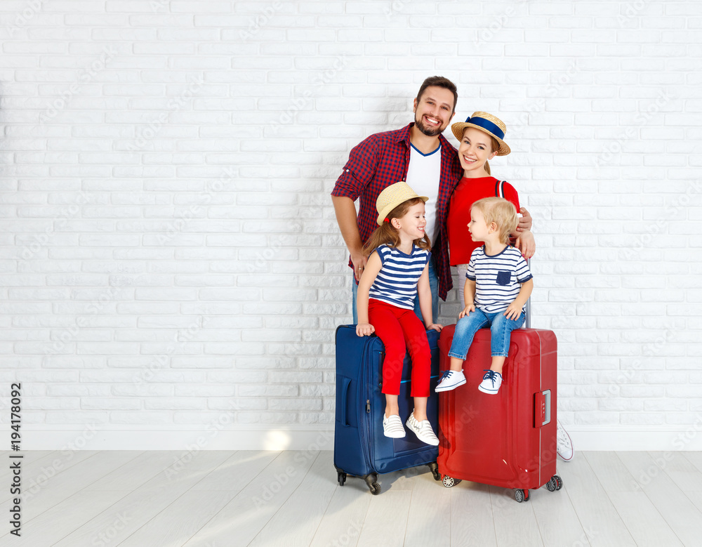 concept travel and tourism. happy family with suitcases near   wall