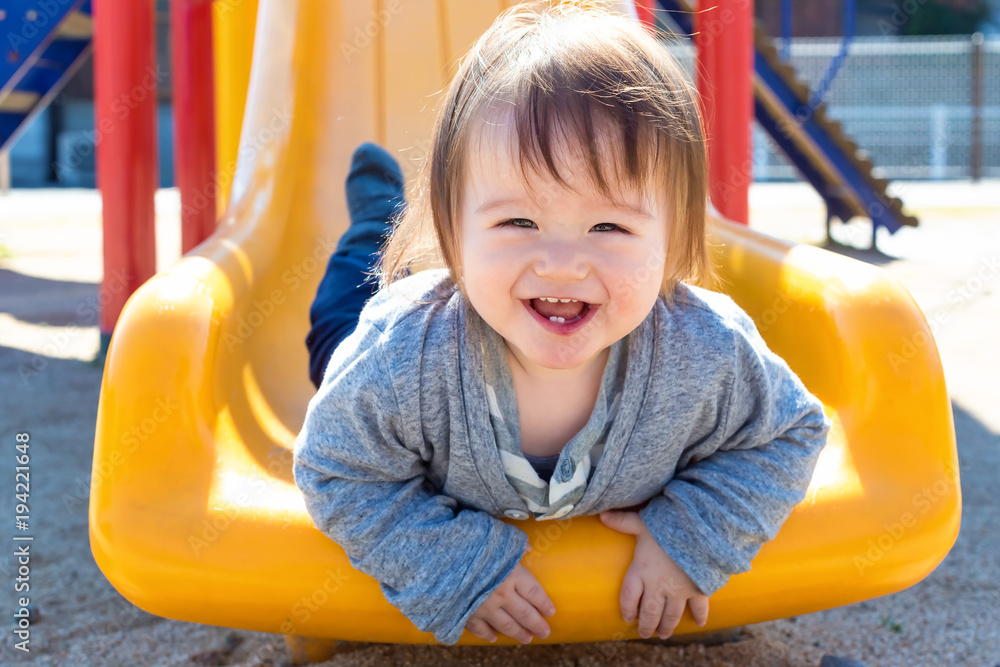 混血幼童在操场上玩滑梯