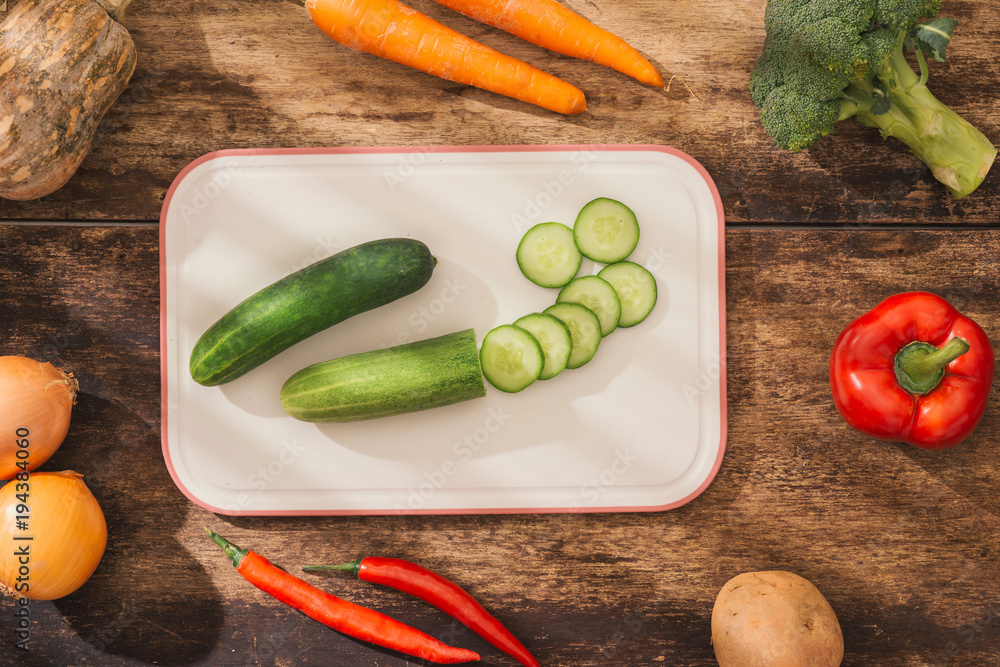 Chopped vegetables on cutting board and ingredients for tasty vegetarian cooking. Top view.