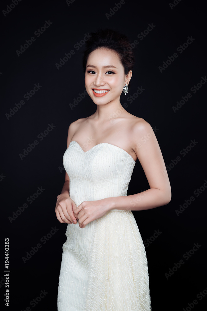 Beautiful woman portrait on black background. Young lady posing with gorgeous make up and hairstyle.