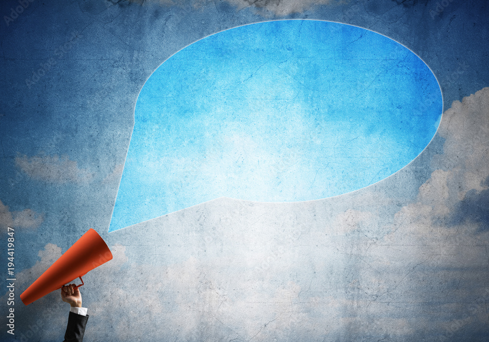 Hand of businesswoman holding red paper trumpet and speech cloud