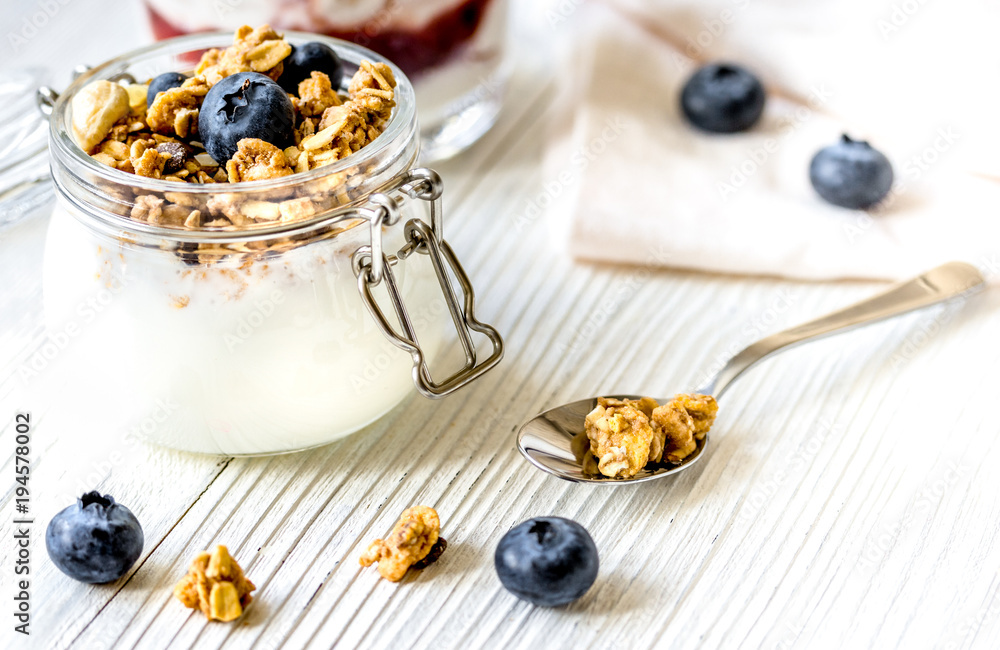 Homemade fitness granola with yoghurt and berries on white kitch