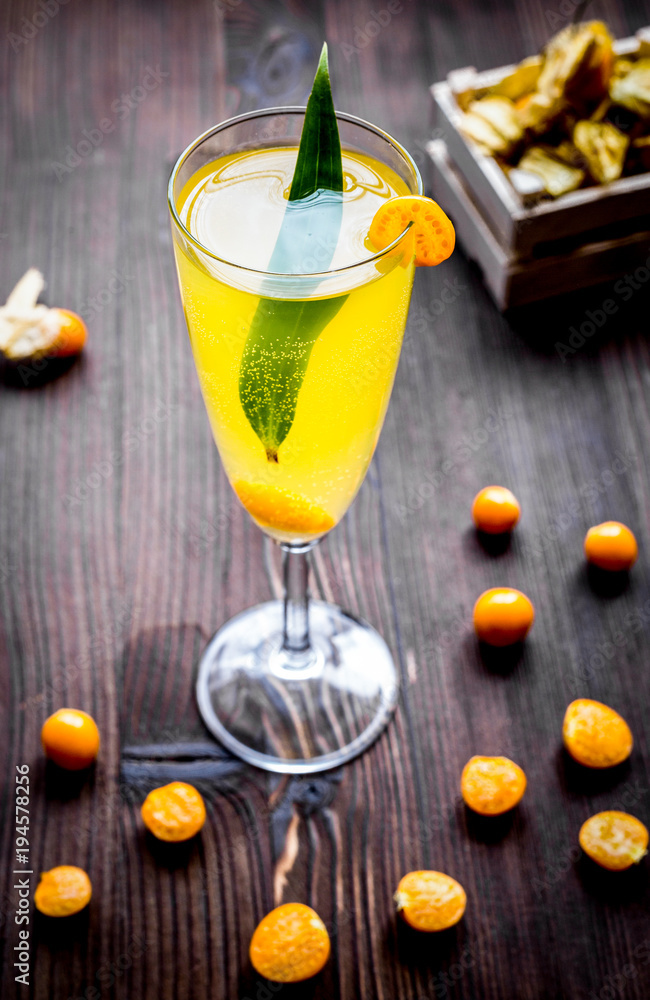 cocktail with physalis in glass on wooden background