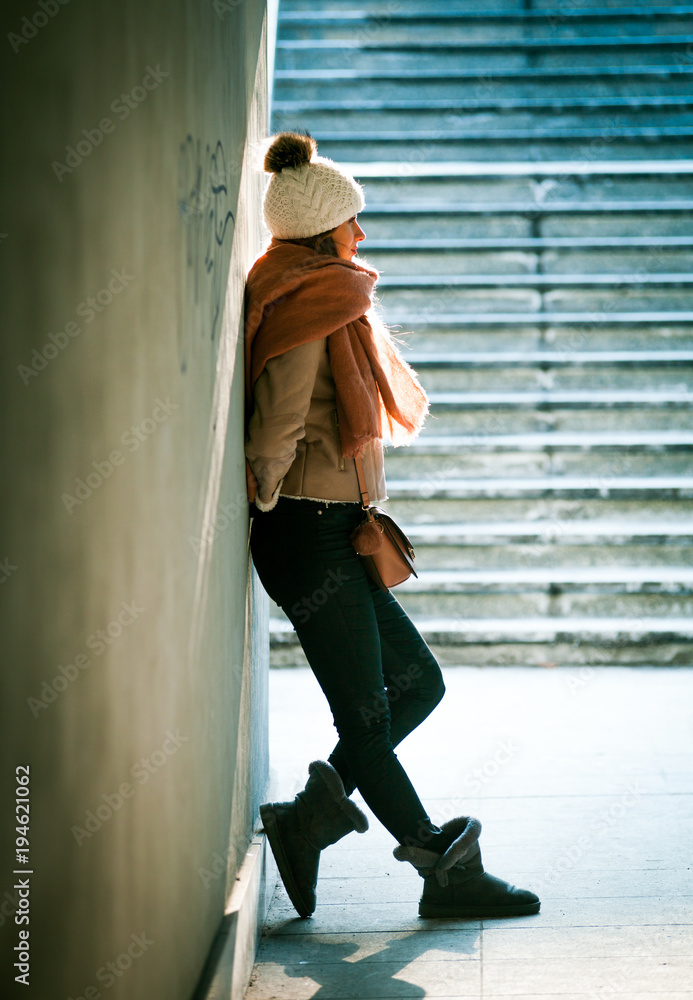 Beautiful girl wearing wool cap in the city street at winter time