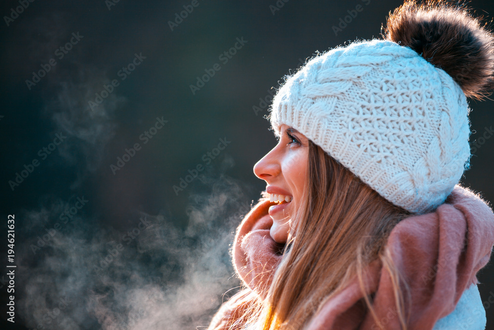 寒冷的冬日，戴着针织毛线帽和大围巾的微笑女人