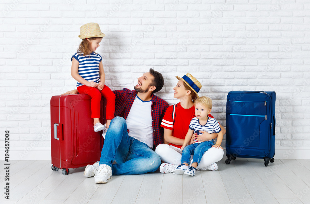 concept travel and tourism. happy family with suitcases near   wall.