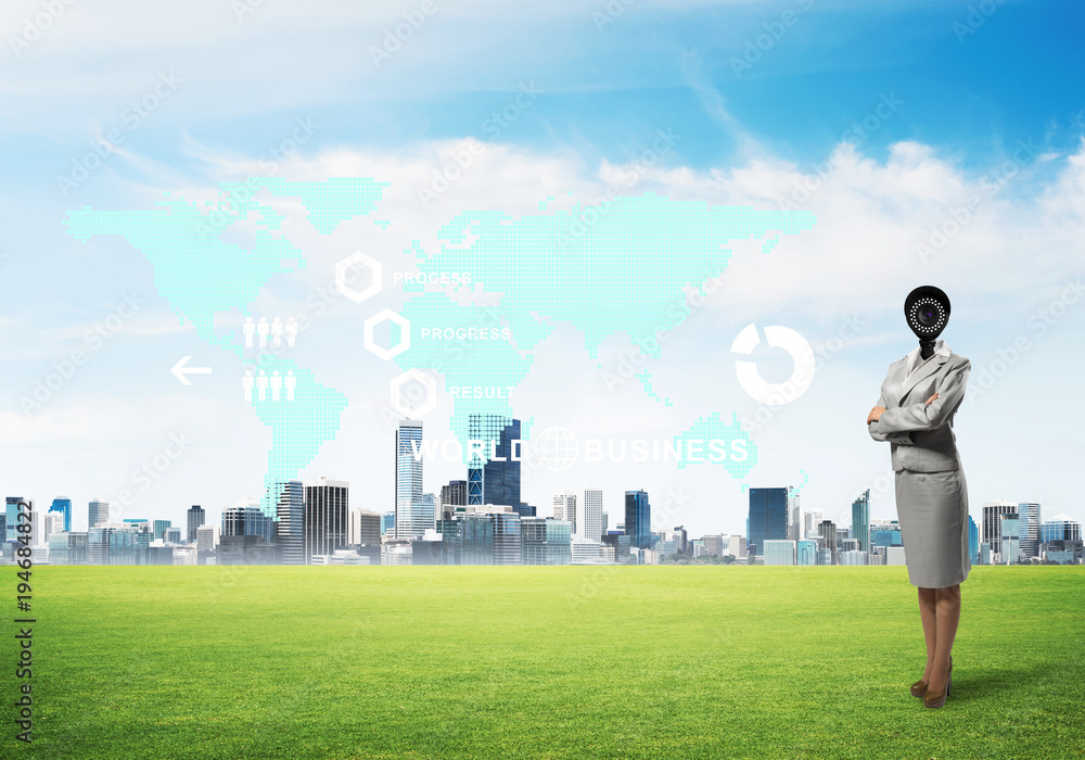 Camera headed woman standing on green grass against modern cityscape