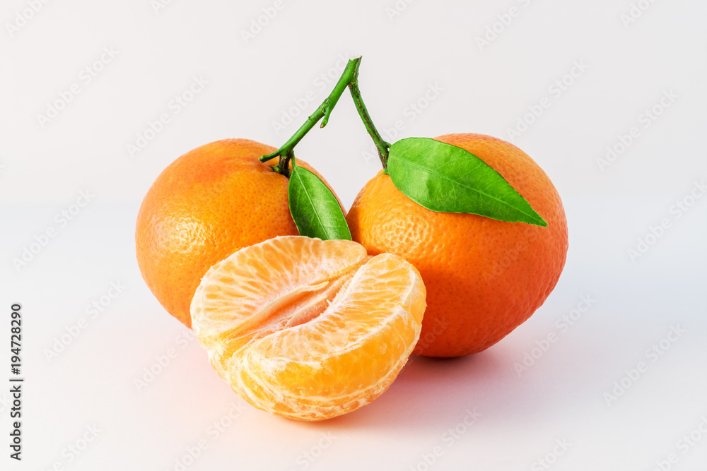 Whole tangerines or mandarines orange fruits and peeled segments isolated on white background