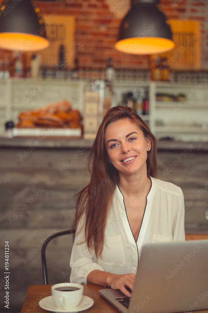 Smiling young woman with a laptop