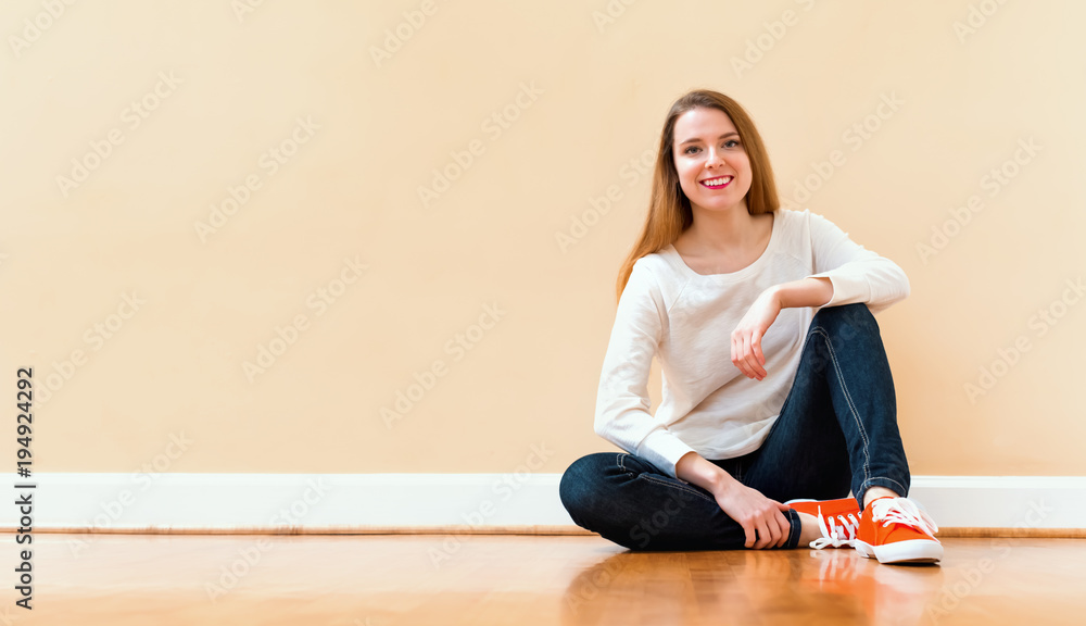 Happy young woman smiling and sitting in a big open room