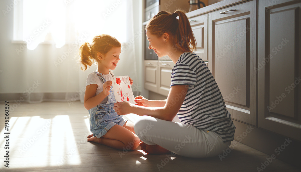 happy mothers day! child daughter congratulates her mother and  read postcard.