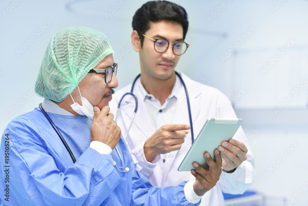 Asian surgeon team using digital tablet at work in operating room