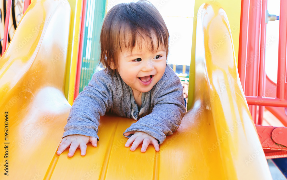 混血幼童在操场上玩滑梯