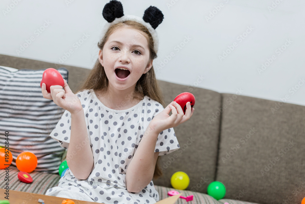 happiness girl kid smile with colorful ball toy on sofa