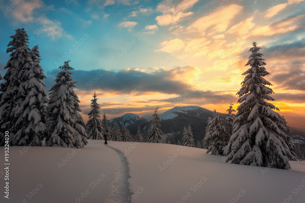 Fantastic orange winter landscape in snowy mountains glowing by sunlight. Dramatic wintry scene with