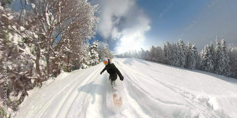 运动型单板滑雪女孩在阳光明媚的山地滑雪场骑着新鲜的粉末雪