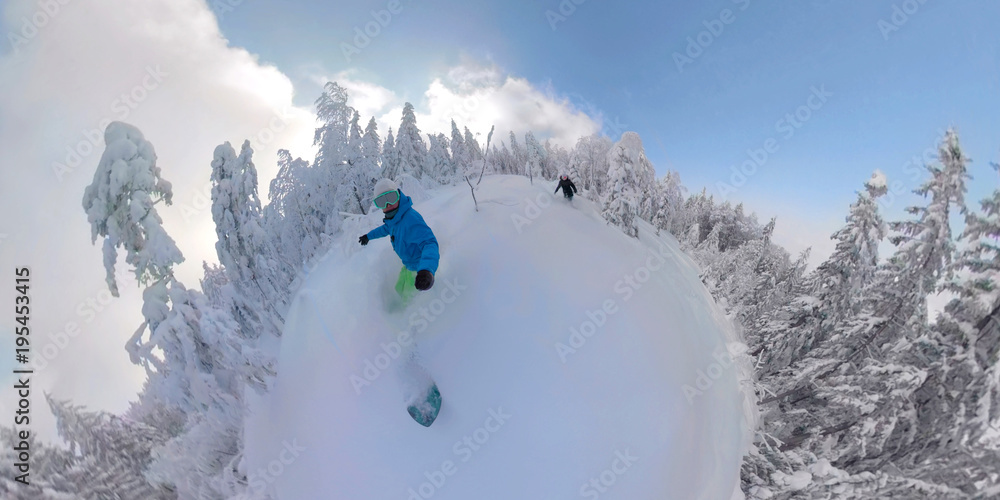 冬季仙境世界，两名免费滑雪板运动员骑着新鲜的粉雪