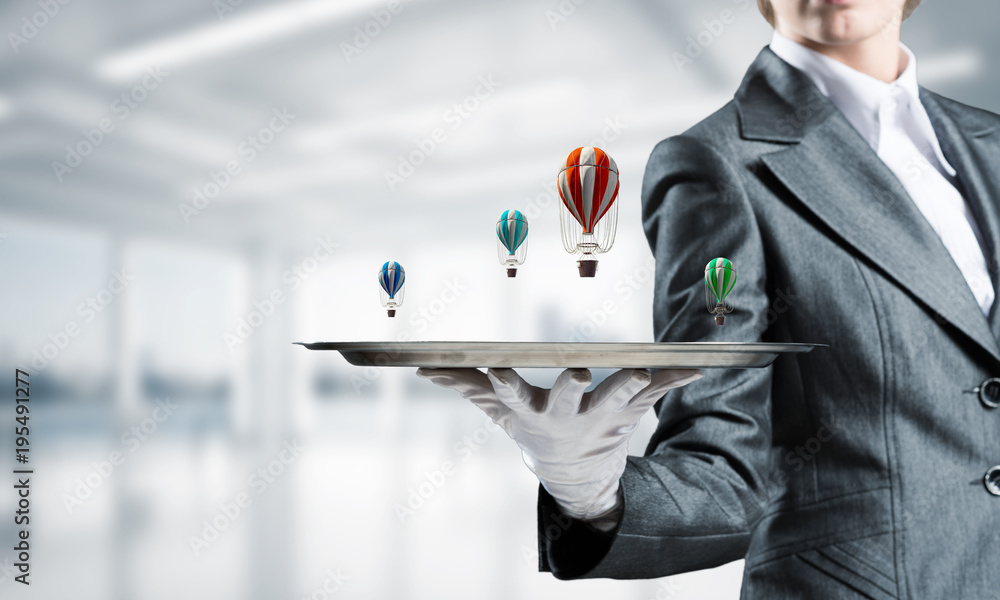 Hand of waiter presenting balloons on tray.