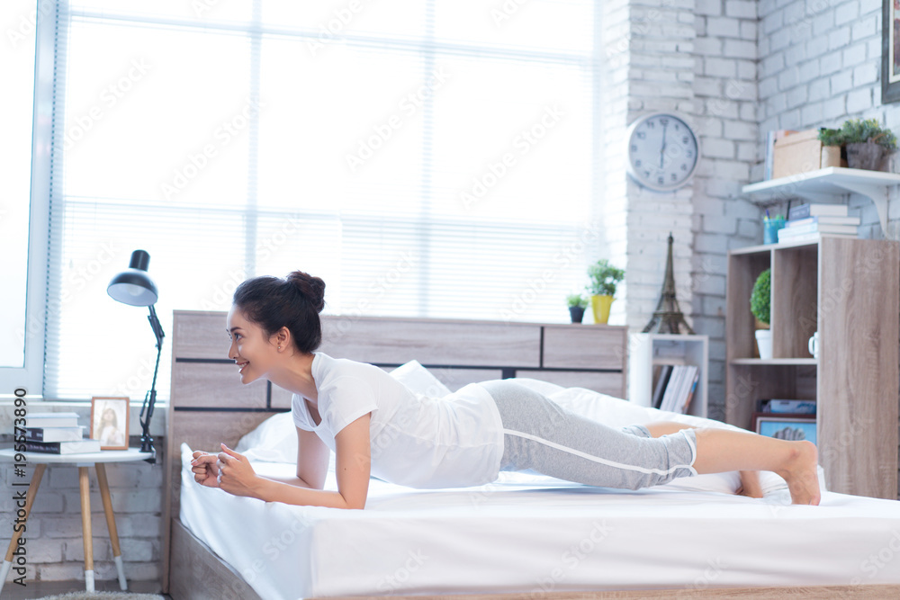 Asian women exercising in bed in the morning, she feels refreshed.She acted plank